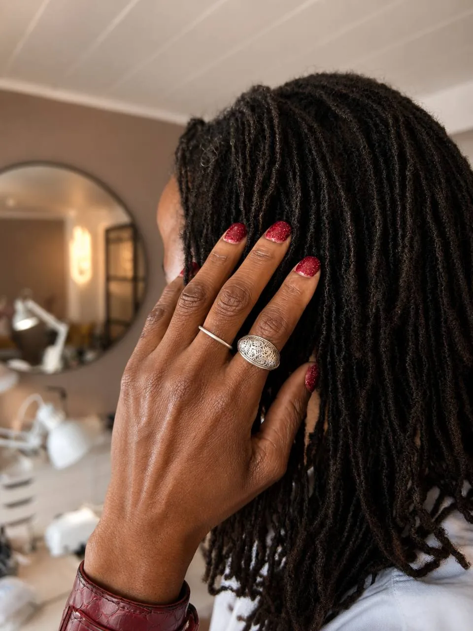 Client showing red glitter nails in the private Marzieh Nail Atelier studio