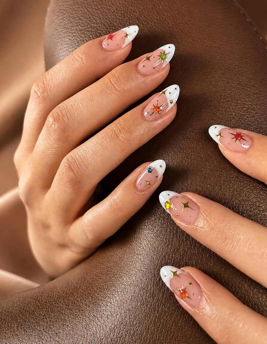 Hvidt French-negledesign med farvede juvel- og stjernedetaljer hos Marzieh Nail Atelier