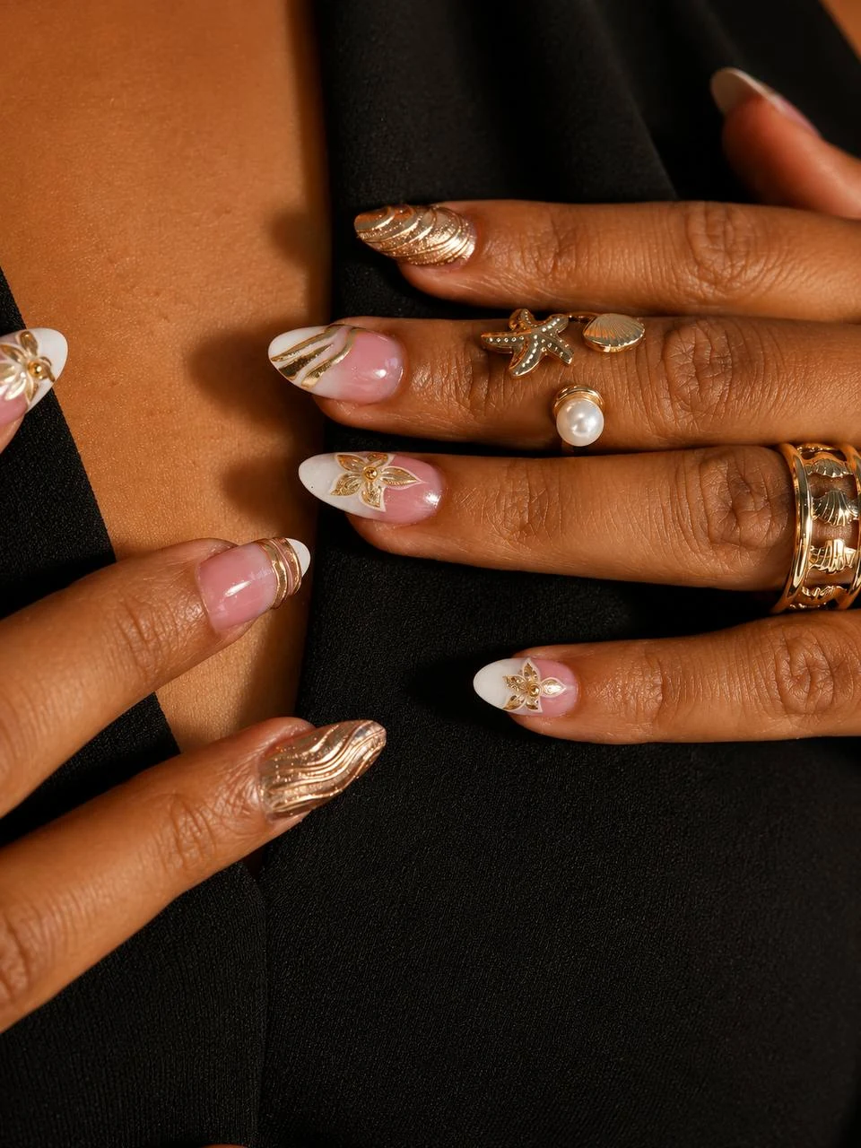 Forgyldt botanisk French-negledesign med skulpturelle gulddetaljer og smykker hos Marzieh Nail Atelier